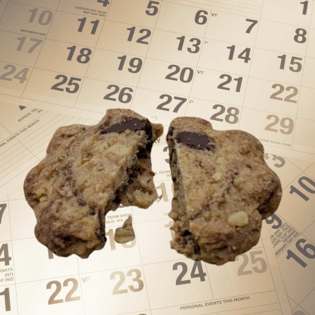 Un cookie artisanal aux pépites de chocolat posé sur un calendrier pour illustrer la durée de conservation des biscuits sans conservateurs.